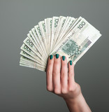 Fototapeta  - wachlarz pieniędzy w ręku kobiety