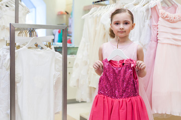 Wall Mural - Beautiful girl tries on a festive red dress in the store