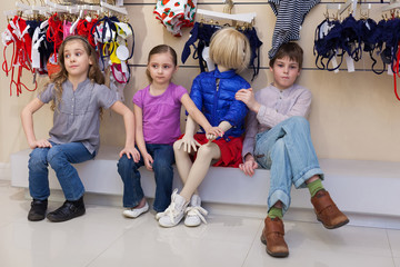 Wall Mural - boy and girls sitting together with mannequins in store