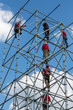 Workers make a work on scaffolding against a blue sky