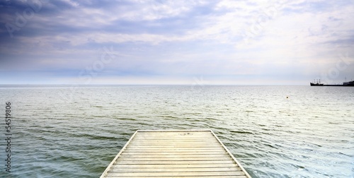 Board z aluminiowym obramowaniem Stare drewniane molo nad morzem