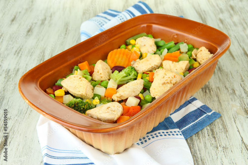 Casserole with vegetables and meat, on wooden background
