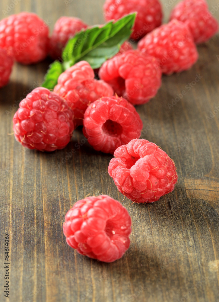 Ripe sweet raspberries on wooden background