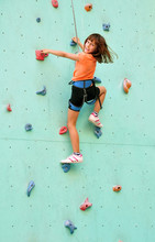 Smiling Child Climbing Up The Wall