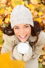 Wall Mural - Autumn woman drinking coffee in fall forest