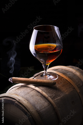 Fototapeta na wymiar Cognac and Cigar on black with vintage barrel