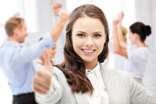 Businesswoman Showing Thumbs Up In Office