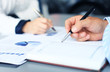 © ty - Unrecognizable business person analyzing graphs and taking notes