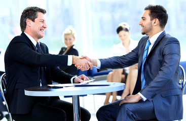 Wall Mural - Two business colleagues shaking hands during meeting