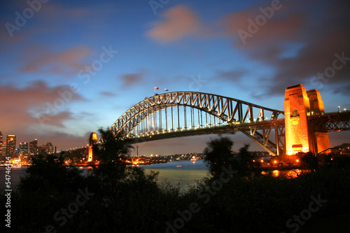 Board z aluminiowym obramowaniem Sydney Harbour Bridge o zmierzchu