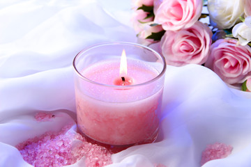 Wall Mural - Beautiful candle with flower on white cloth, close up