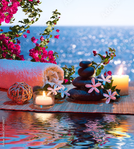 Fototapeta do kuchni Candles - black stones and tiare - Bougainvillea on water