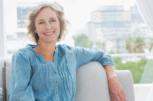 Happy woman relaxing on her couch Tableau sur Toile
