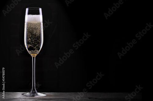 Fotomural glass of champagne isolated on black background