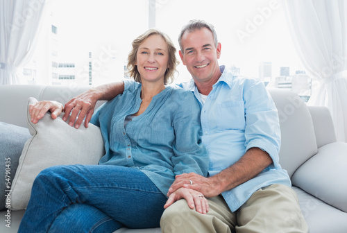 Poster Middle aged couple relaxing on the couch