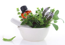 Mortar And Pestle With Fresh Herbs And Essential Oil Bottle