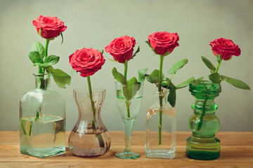 Wall Mural - Rose flowers in vases, bottles and glasses