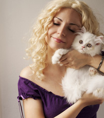 Wall Mural - Beautiful young woman holding white Persian kitten