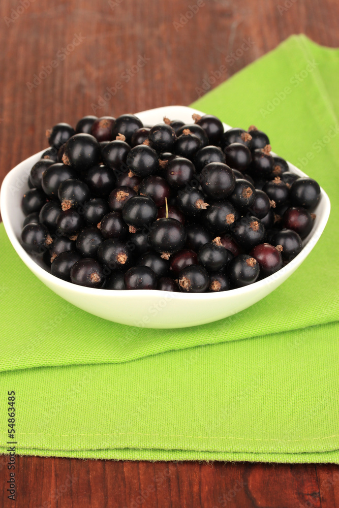 Fresh black currant on wooden background