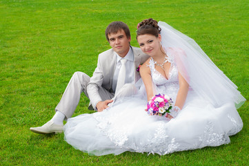 Young and beautiful bride and groom smiling at each other