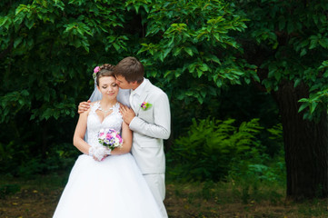 Young and beautiful bride and groom smiling at each other