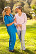 friendly caregiver talking to senior woman outdoors