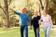 © michaeljung - middle aged couple taking elderly mother for a walk