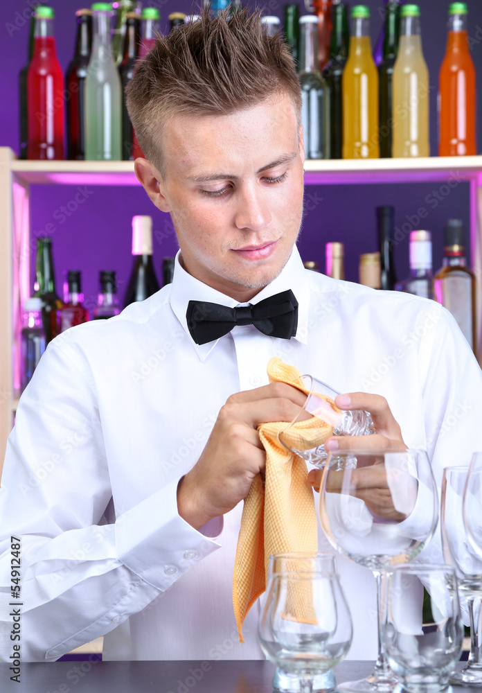 Bartender wipes glasses at work