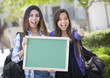 © Andy Dean - Mixed Race Female Students with Thumbs Up Holding Blank Chalkboa