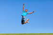 © Samuel B. - Outdoor portrait of a cute teenage black boy jumping over a blue