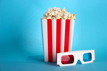 Popcorn and 3D glasses on blue background