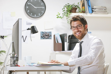 Young businessman in office looking at camera.