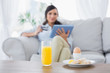 © WavebreakmediaMicro - Peaceful brunette having breakfast while buying online