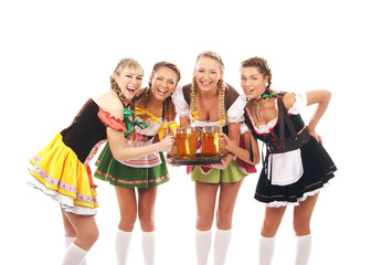 Wall Mural - Four young women in Bavarian clothes holding glasses of beer