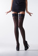 © Acronym - Sexy female legs in black erotic stockings and high heels