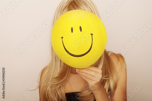 Girl holding smiley face balloon in front of her Poster