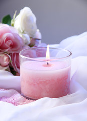 Wall Mural - Beautiful candle with flower on white cloth, close up