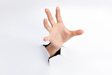 Female Hand Reaching Through Torn Paper Sheet