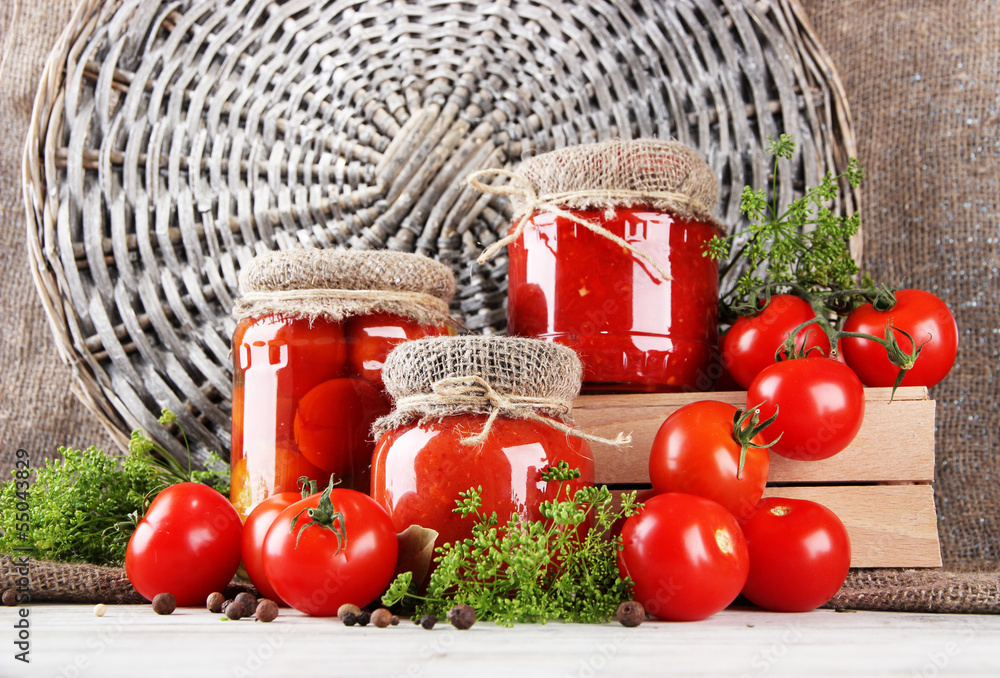 Tasty canned and fresh tomatoes on wooden table