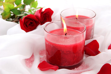 Wall Mural - Beautiful candles with flowers on white cloth, close up