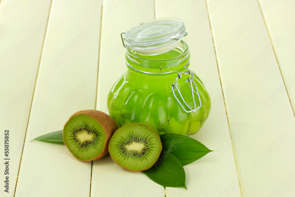 Jar of jam kiwi on wooden table close-up