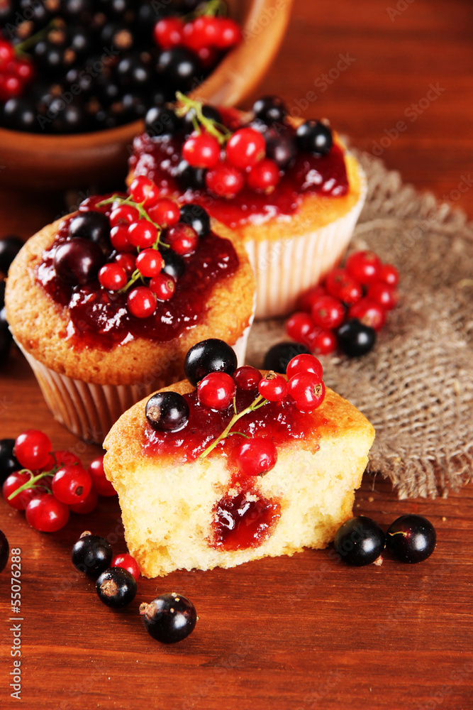 Tasty muffins with berries on wooden table