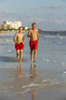 © travelview - father and son enjoy jogging along the beach