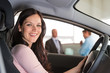 © CandyBox Images - Smiling woman sitting in car in showroom