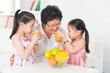 © WONG SZE FEI - Asian family drinking fresh orange juice