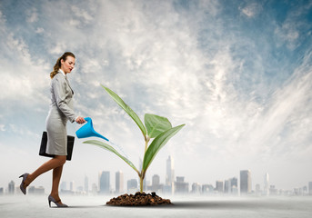 Business woman watering sprout