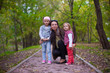 © travnikovstudio - Young mother with her little daughters looking to camera oudoor
