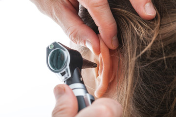 examining ear with otoscope