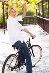 Wall Mural - middle aged woman on a bike waving