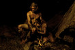 Primitive man and his woman sitting near the fire in the cave